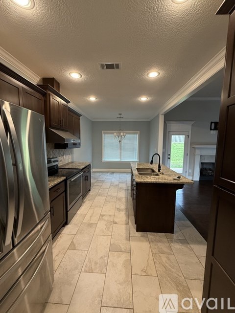 A kitchen with a stainless steel refrigerator and dark wood cabinets.