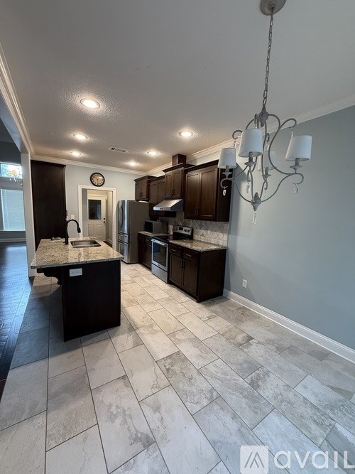 A kitchen with a marble floor and a chandelier hanging from the ceiling.