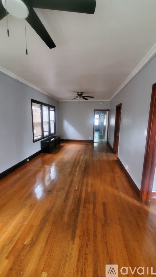 A room with wooden floors and a ceiling fan.
