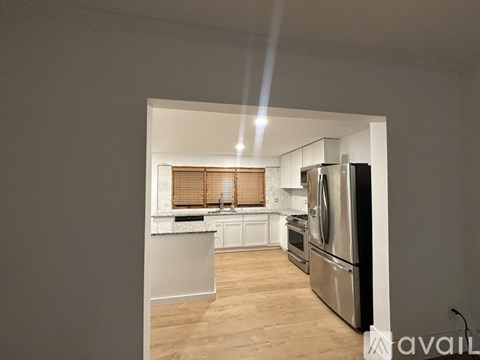 A kitchen with a refrigerator, oven, and sink is available for rent.