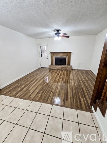 A room with a fireplace and a fan on the ceiling.