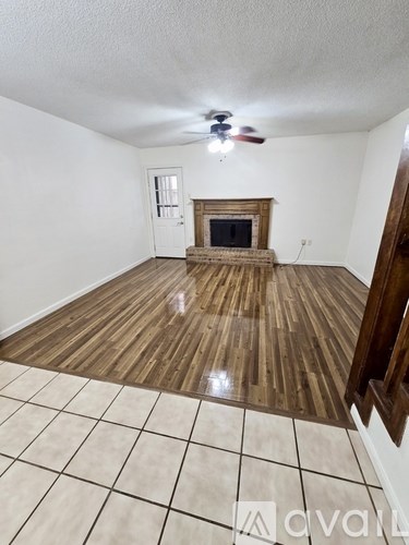 A room with a fireplace and a fan on the ceiling.