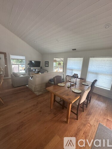 A living room with a wooden table and chairs.