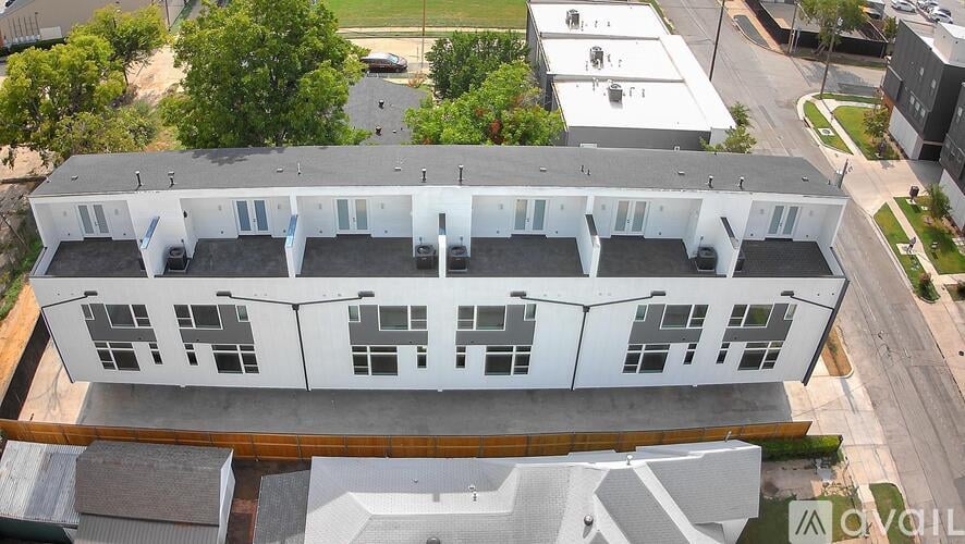 An aerial view of a white building with a grey roof.