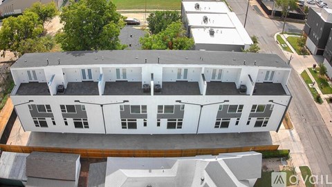 An aerial view of a white building with a grey roof.