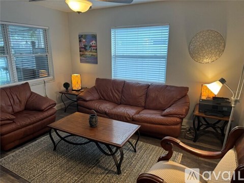 A living room with brown leather furniture and a wooden coffee table.