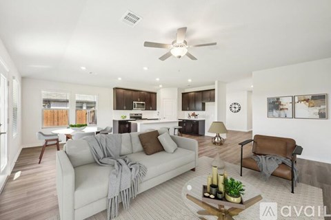 A living room with a white couch and a ceiling fan.