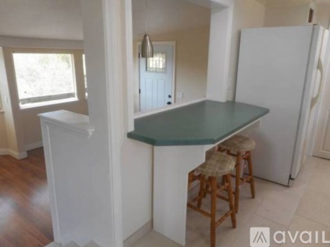 A kitchen with a table and two stools.