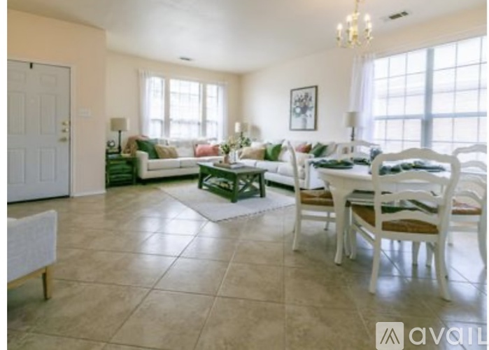 A living room with a dining table set up with chairs.