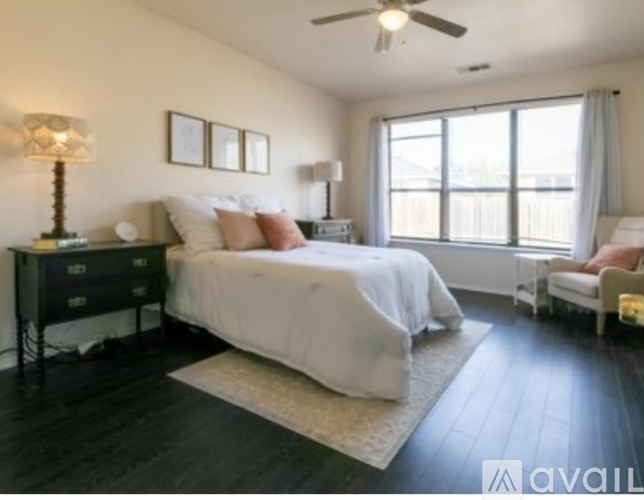A bedroom with a bed, nightstand, and chair.