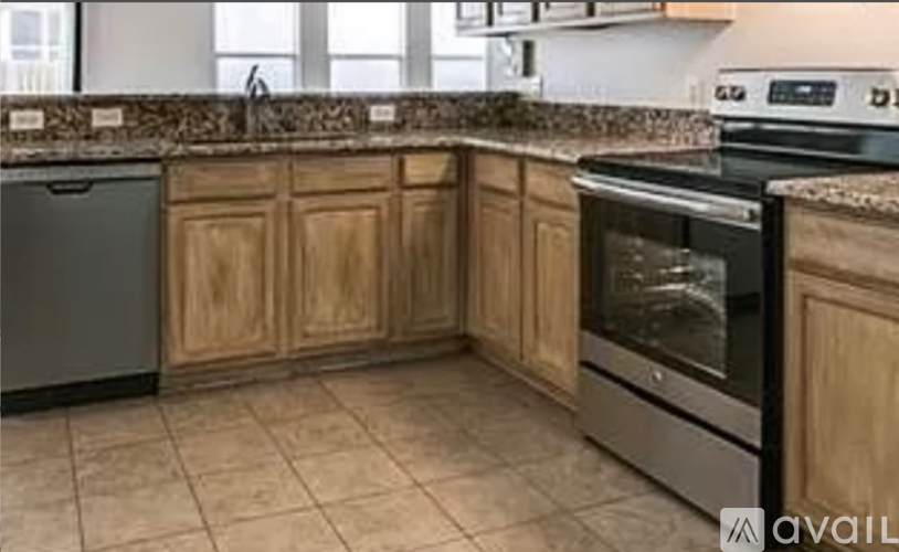 A kitchen with wooden cabinets and a granite countertop.