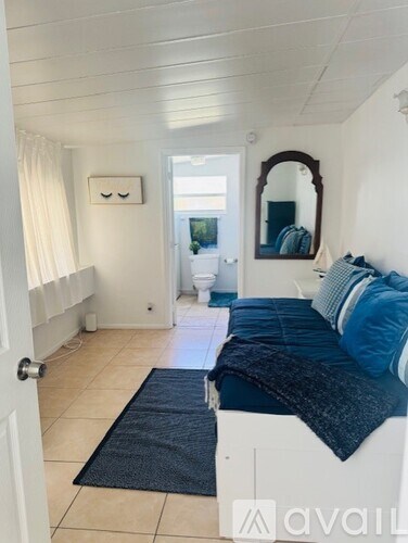 A bedroom with a bed and a mirror on the wall.