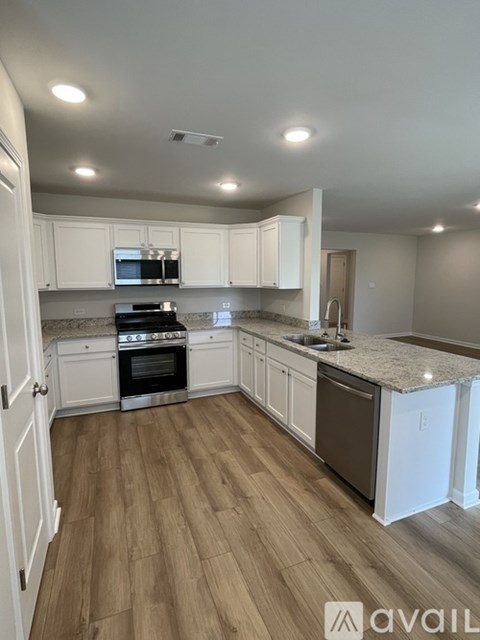A kitchen with white cabinets and a black stove top oven.