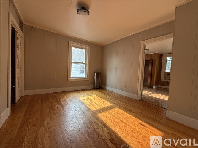 A room with wooden flooring and a window.