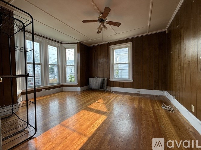 A room with wooden floors and a ceiling fan.