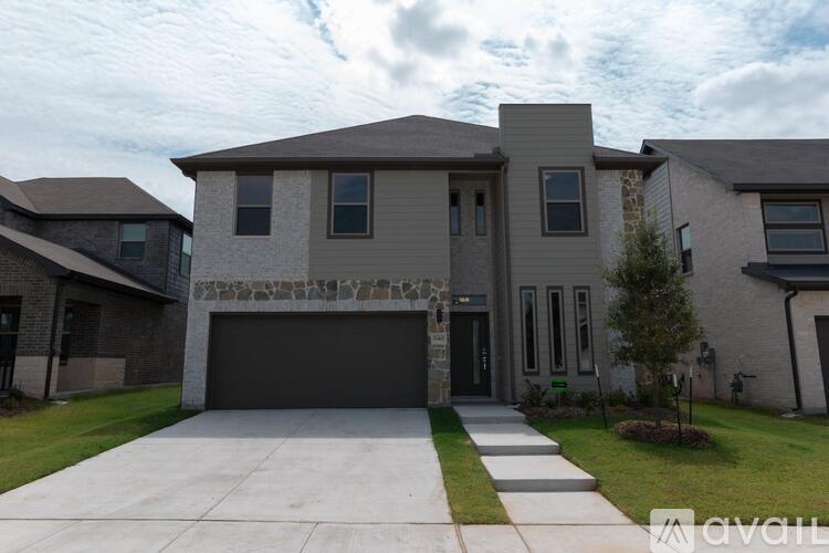 A modern house with a stone pillar entrance and a garage door.