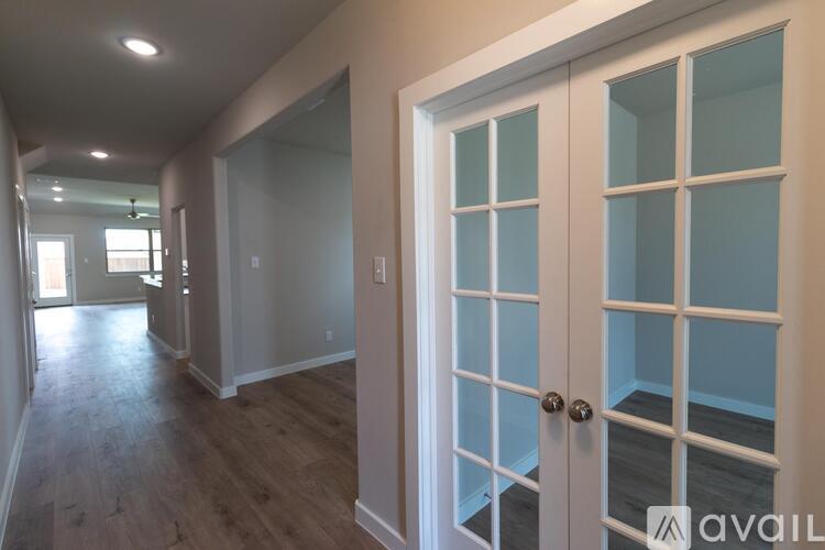 A hallway with a white door and a window.
