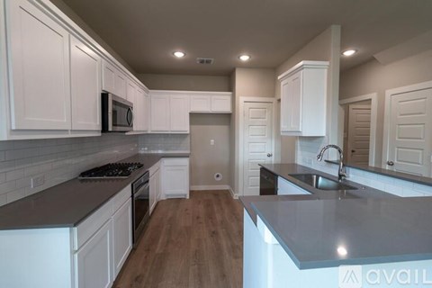 A kitchen with white cabinets and a grey countertop.