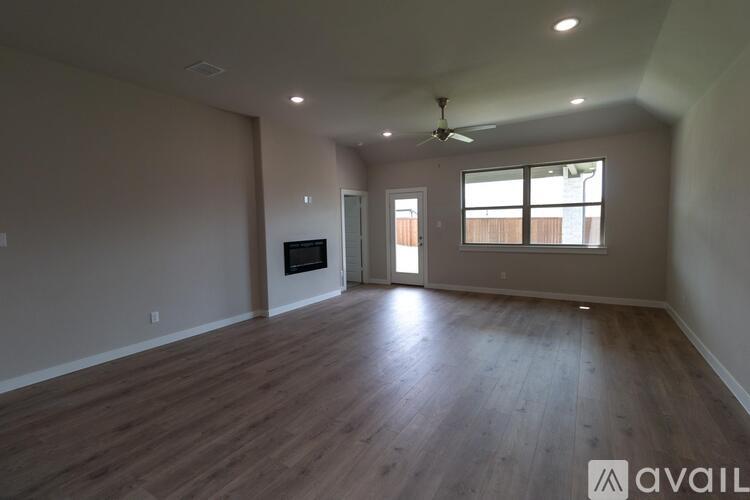 A spacious room with wood flooring and a ceiling fan.