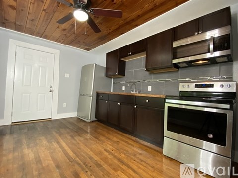 A kitchen with wooden floors and stainless steel appliances.
