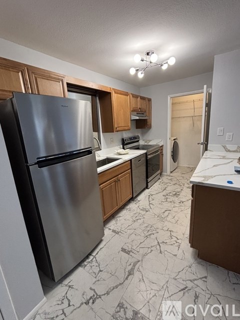 A kitchen with a marble floor and a refrigerator.