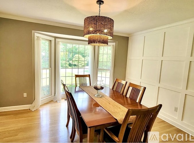 A dining room with a wooden table and chairs.