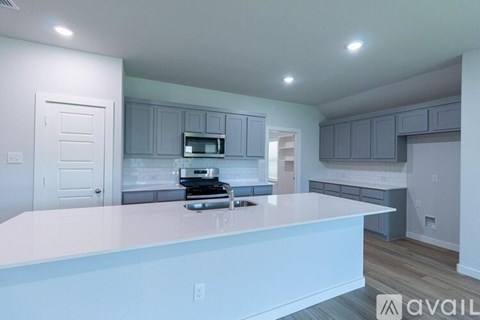 A kitchen with a white countertop and grey cabinets.