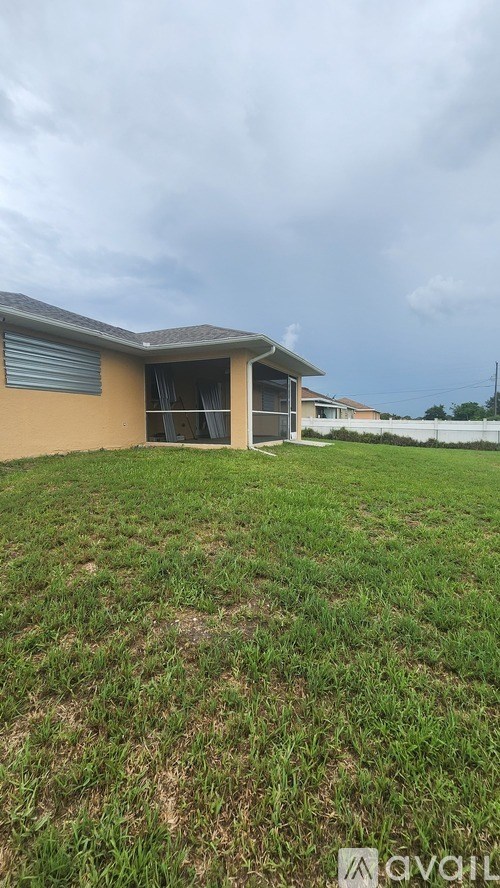 A house with a brown roof and a green lawn in front.