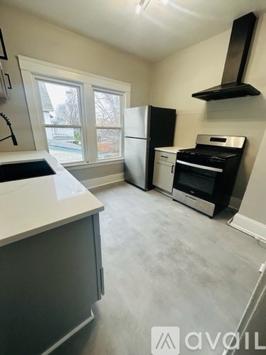 A kitchen with a white counter top and a window.