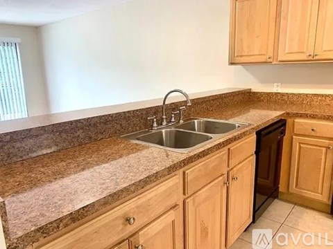 A kitchen with wooden cabinets and granite countertops.