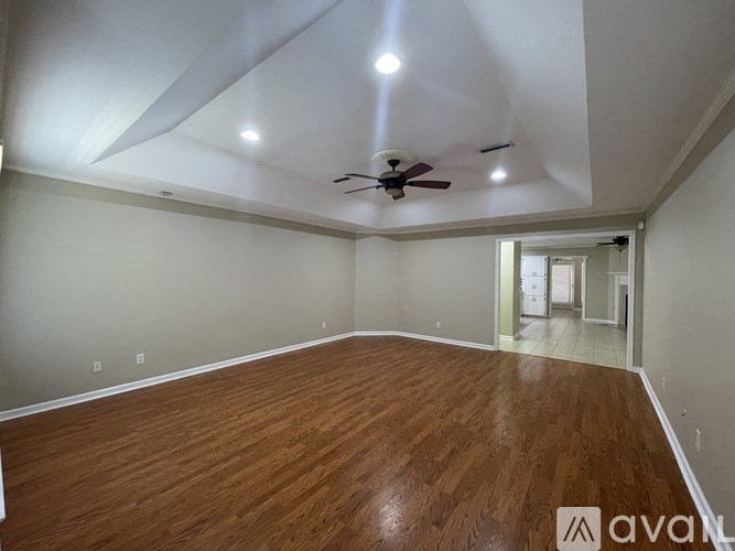 A room with wooden flooring and a ceiling fan.