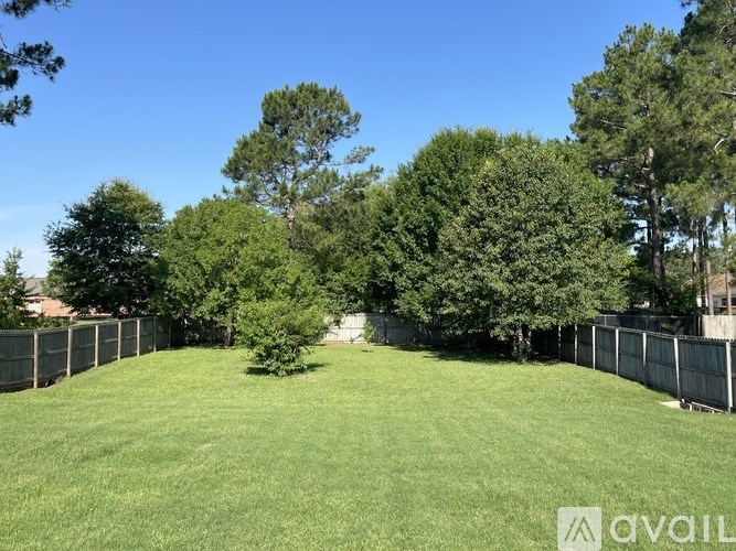 A backyard with a fence and trees.