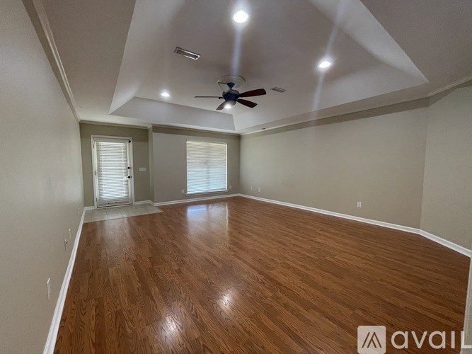 A room with wooden flooring and a ceiling fan.