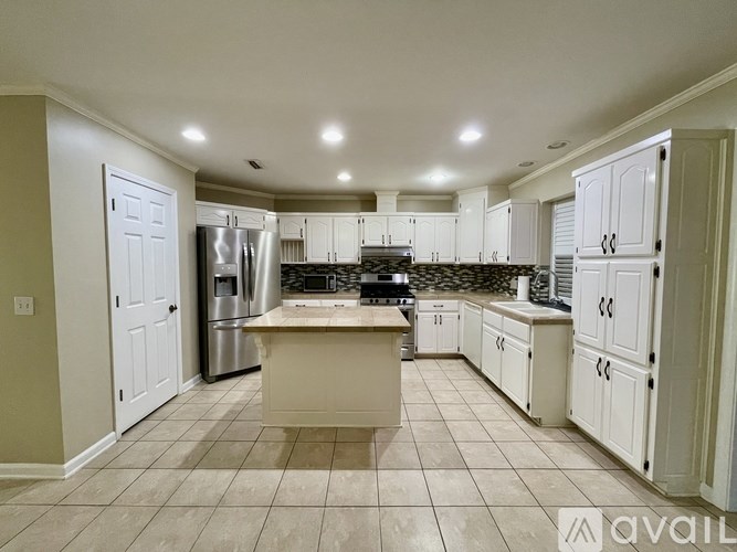 A kitchen with white cabinets and a central island.