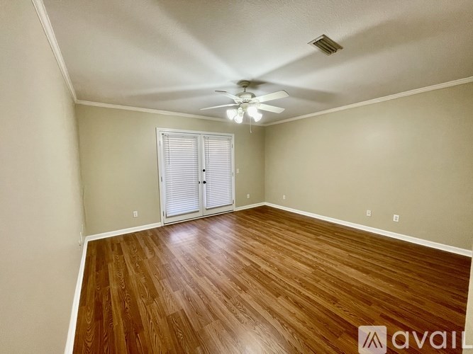A room with wooden flooring and a ceiling fan.