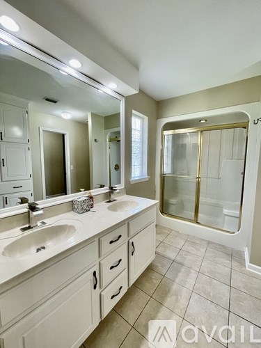 A bathroom with a double sink vanity and a walk-in shower.