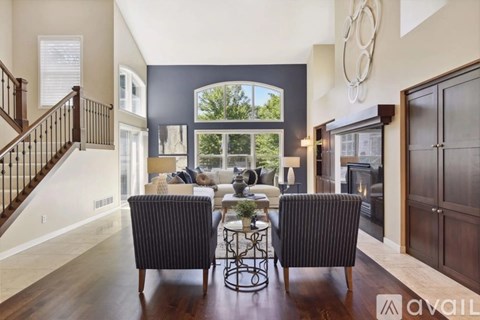 A living room with a black and white striped chair in front of a fireplace.