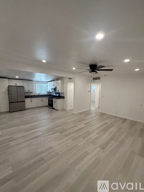 A spacious room with a ceiling fan and lighting fixtures.