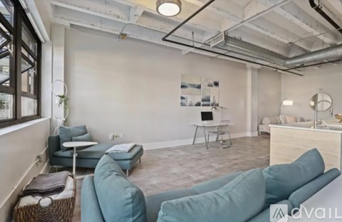 A living room with a white table and a grey sofa.