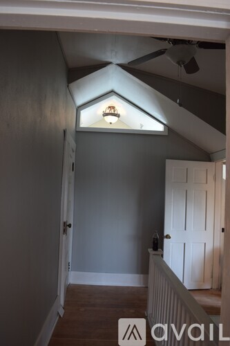 A room with a white door and a ceiling fan.