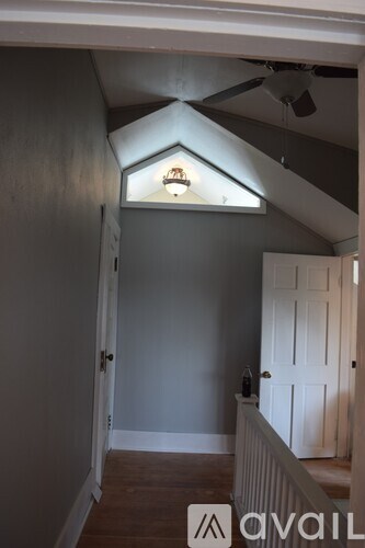 A room with a white door and a ceiling fan.
