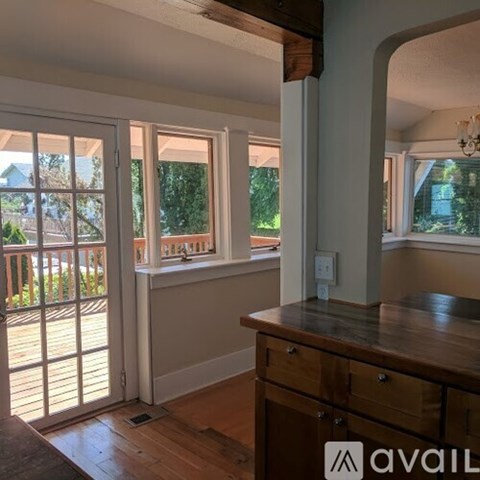 A kitchen with a wooden counter and a window with a view of a house.