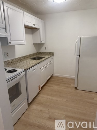 A kitchen with white appliances and cabinets.