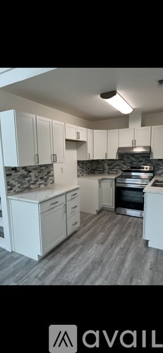 A kitchen with white cabinets and a grey countertop.