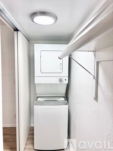 A white washing machine in a small laundry room.