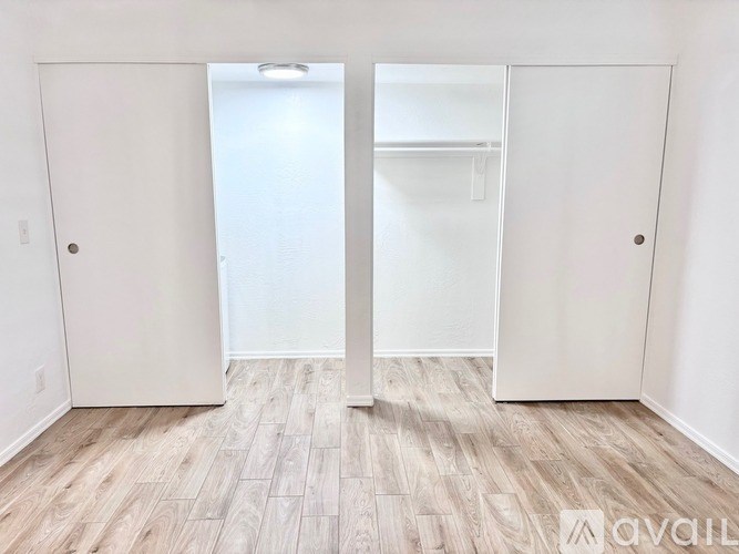 A room with a white door and a white closet with shelves.