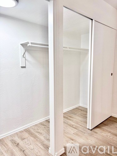 A white closet with a sliding door and a shelf.