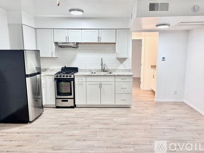A kitchen with black appliances and white cabinets.
