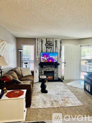 A living room with a fireplace and a television on the wall.