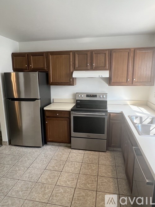 A kitchen with a stainless steel refrigerator, oven, and cabinets.